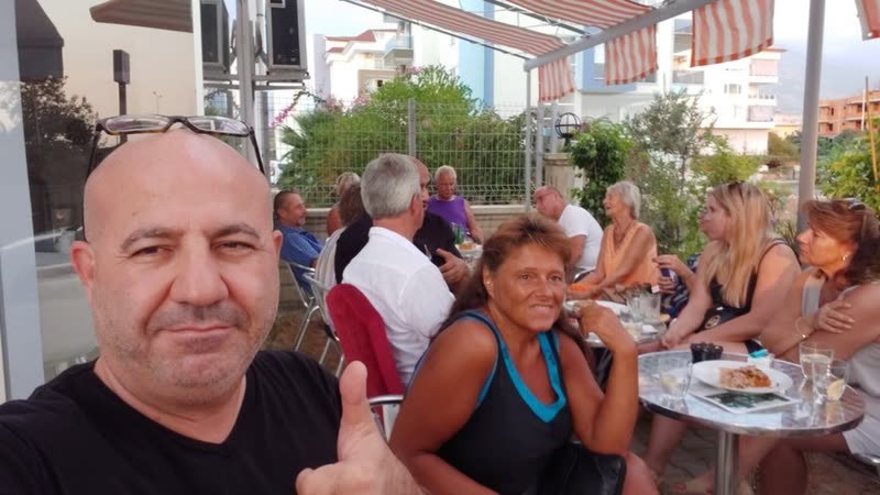 Ali mit einer fröhlichen Gruppe beim Kaffee