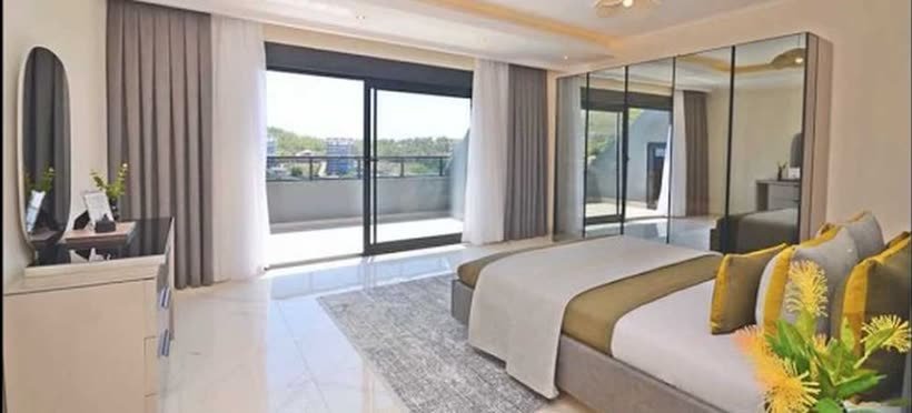 Schlafzimmer mit großer Fensterfront und Zugang zur Terrasse