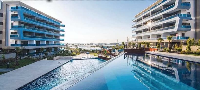 Große Poollandschaft vor einer modernen Wohnanlage