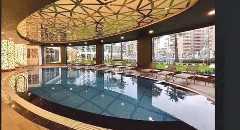 Beleuchteter Innenpool mit gemusterter Holzdecke
