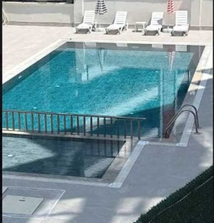 Pool einer Wohnanlage mit Geländer und Liegen